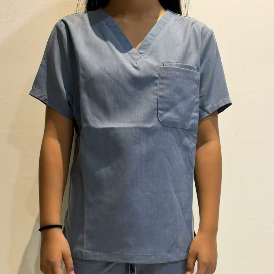 Person wearing a blue scrub top against a beige background